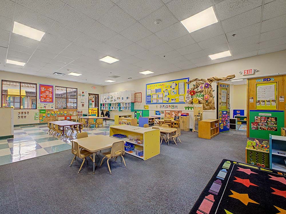 Empty classroom with small tables and chairs