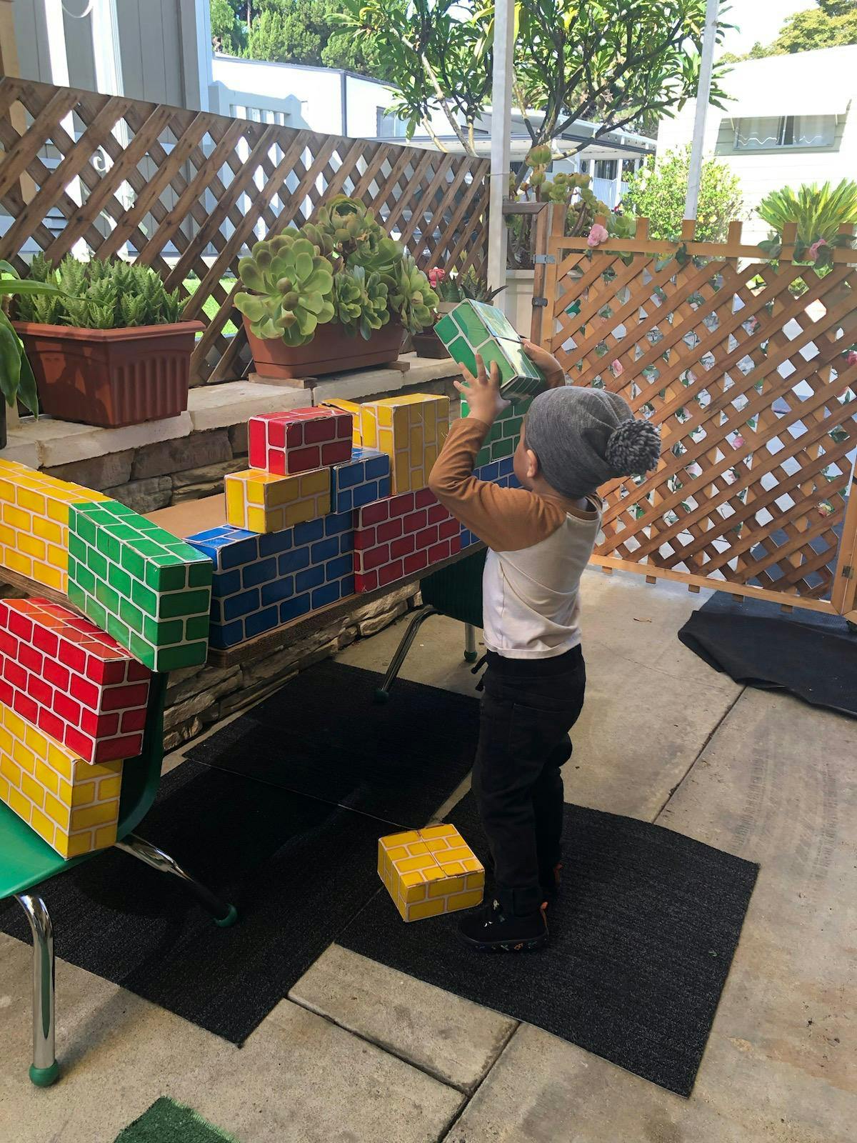 Child playing with colorful building blocks outdoors