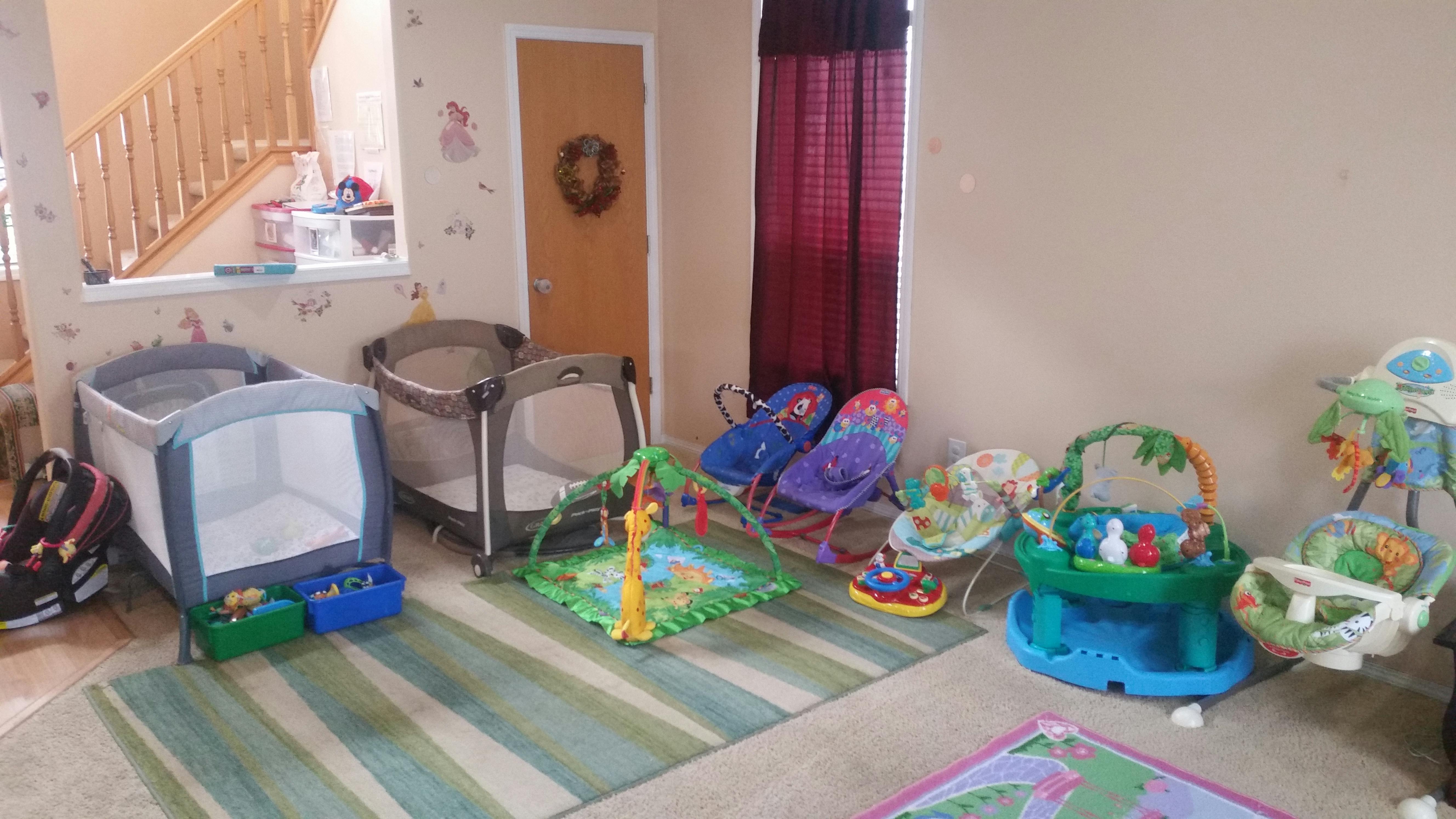 Collection of infant activity centers and a playard in a living space