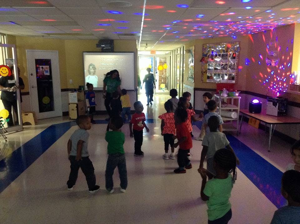 Children dancing in a room with disco lights