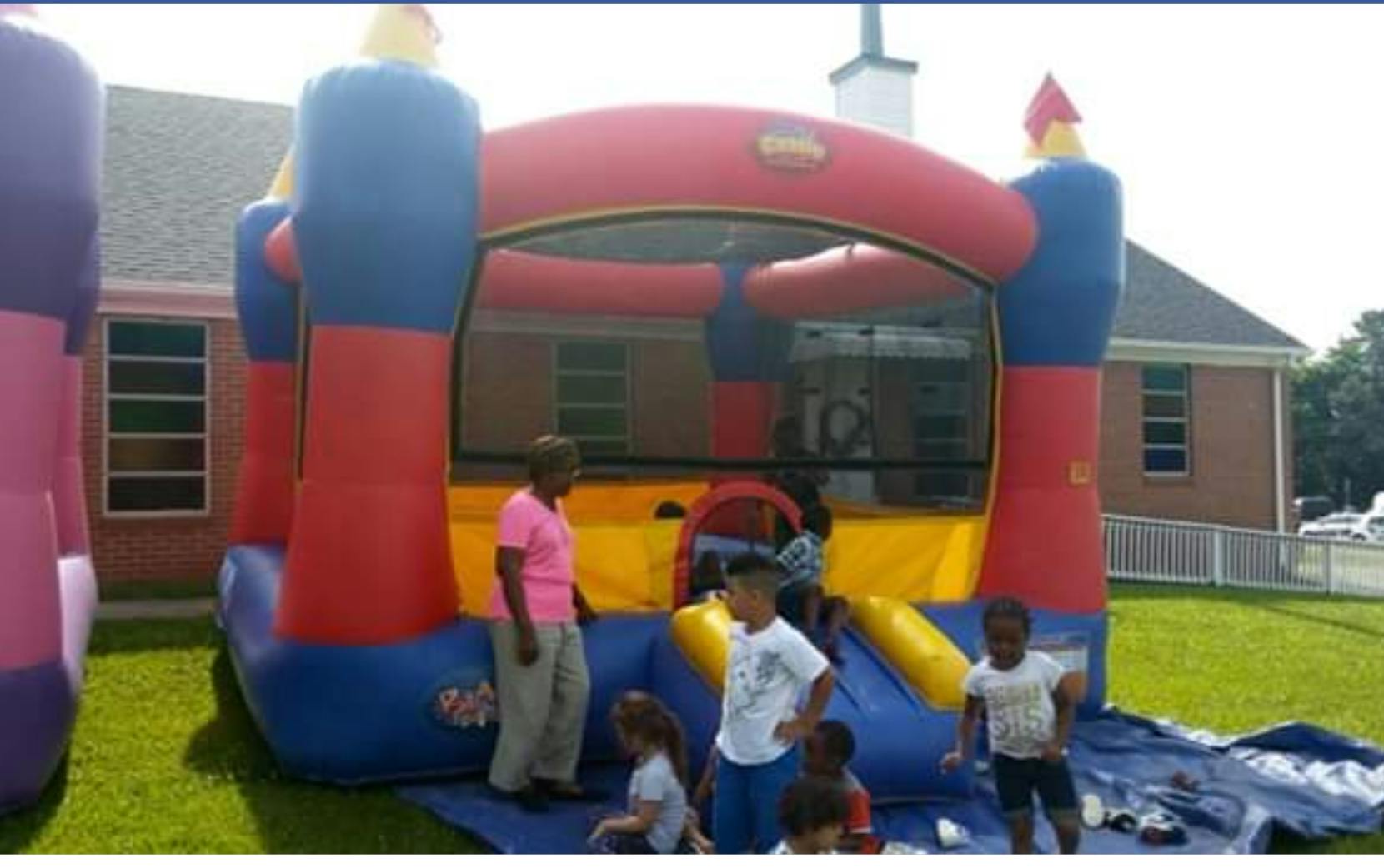 Children playing on and around a colorful inflatable bounce house