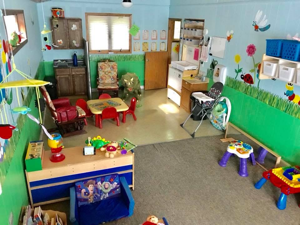 Playroom with small tables and chairs, toys, and wall decorations