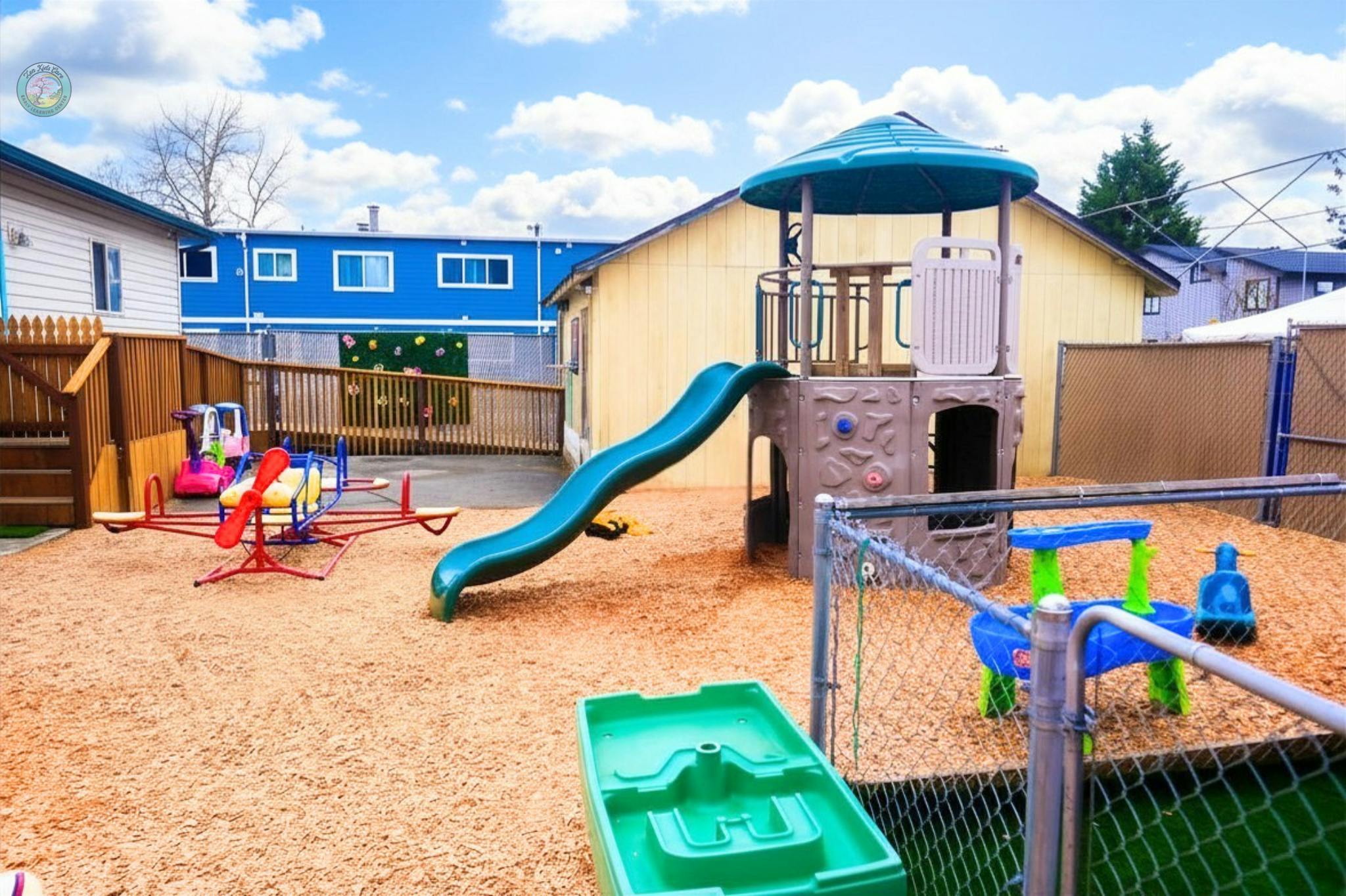 A colorful playground with a slide, climbing structure, and merry-go-round