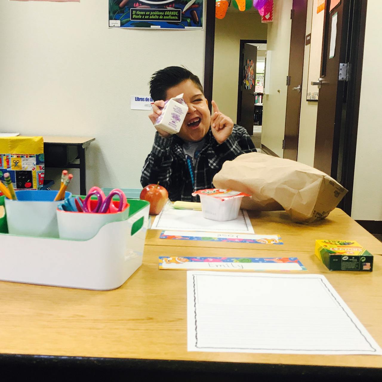 Child holding a milk carton and pointing