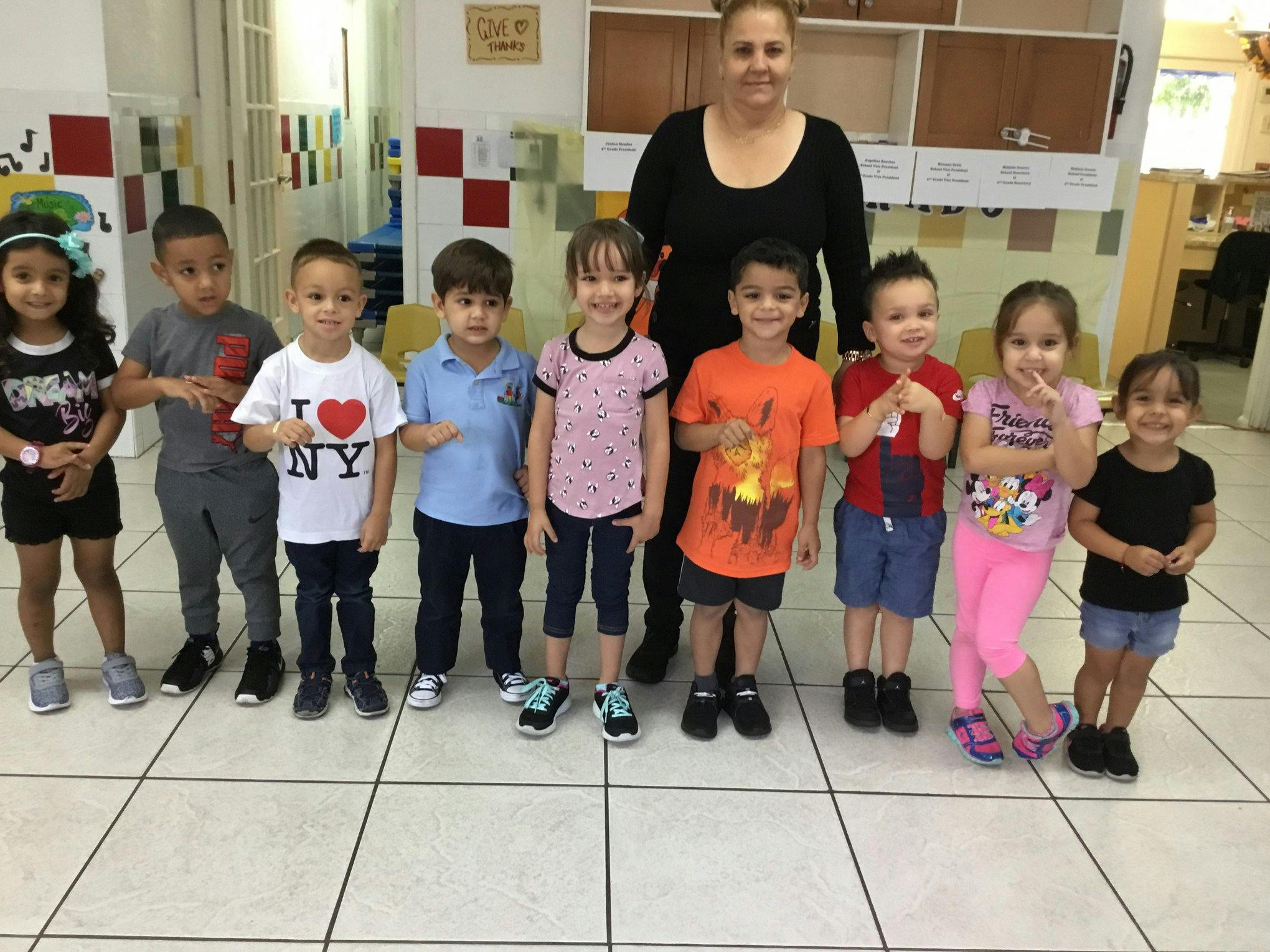 Adult and group of children standing in a line