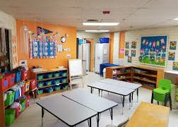 Empty classroom with tables and shelves