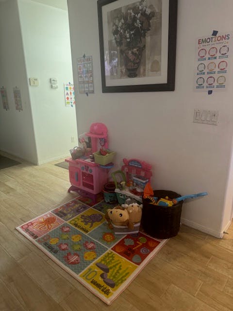 Children's play kitchen and toys on a colorful rug