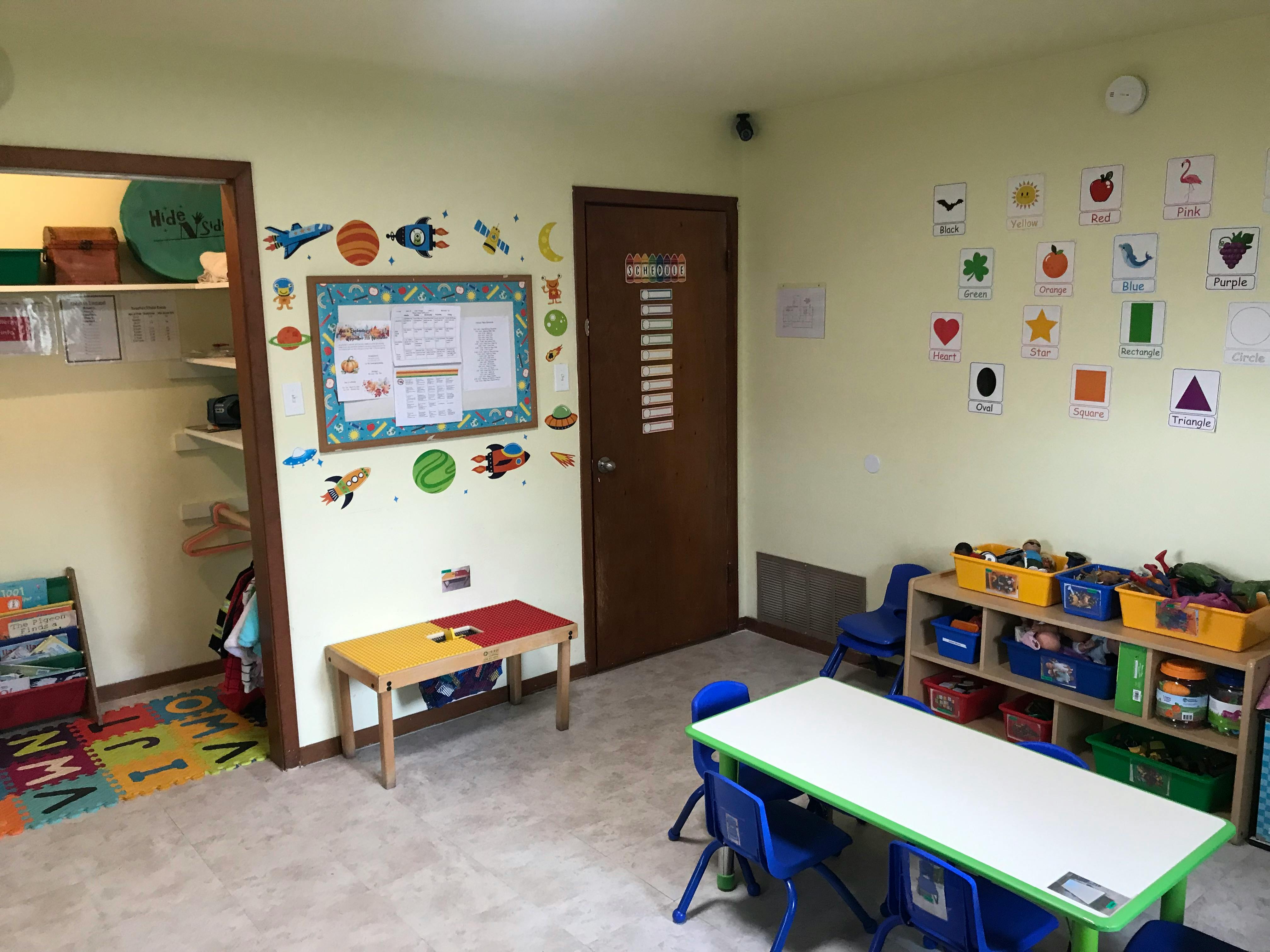 Classroom with small tables, chairs, and decorations on the walls