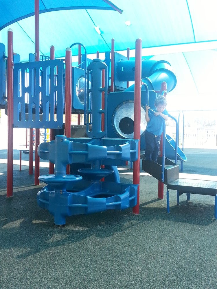 Child on a blue playground structure