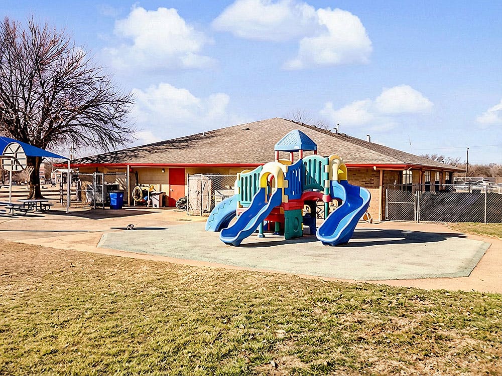 Playground structure with slides and climbing area outside a building
