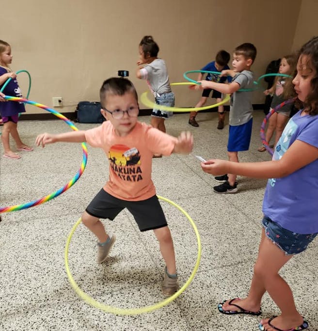 Children playing with hula hoops indoors