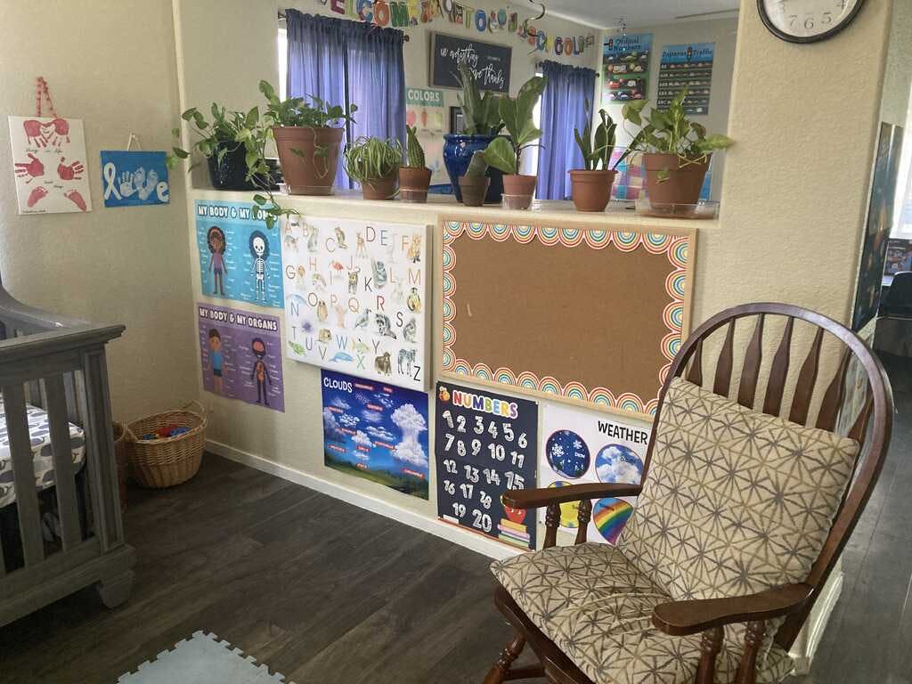 crib, rocking chair, and educational posters in a room