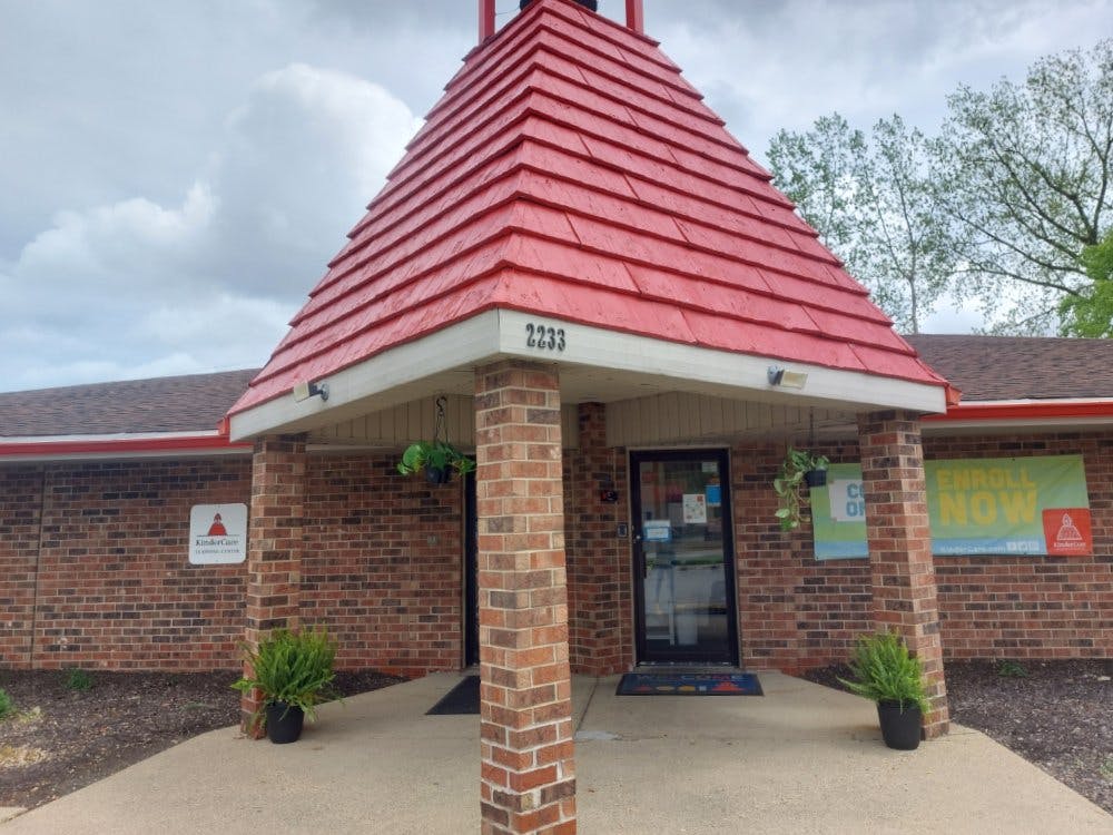 Brick building entrance with a red-shingled roof