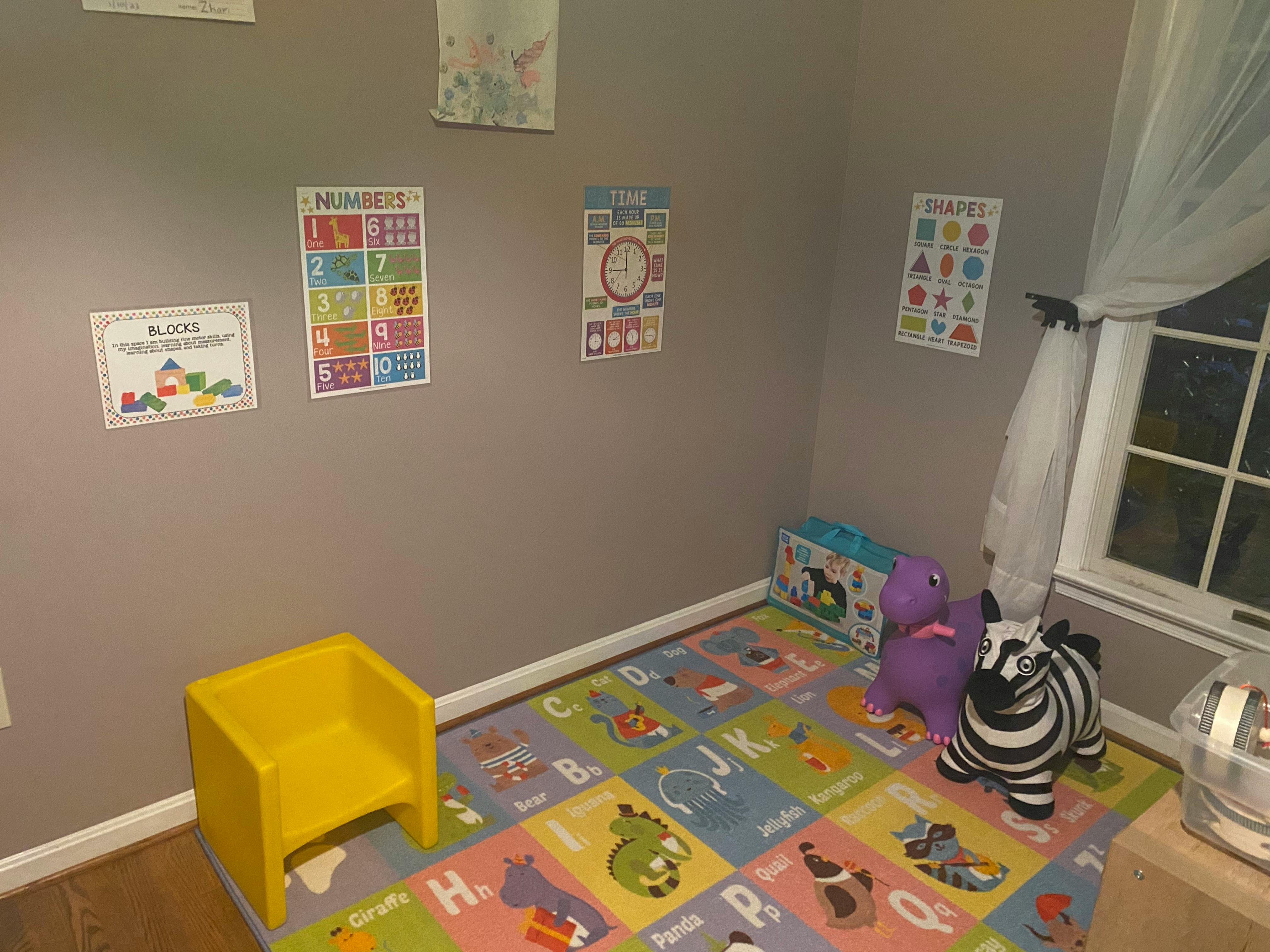 Playroom with alphabet mat, yellow chair, and toys