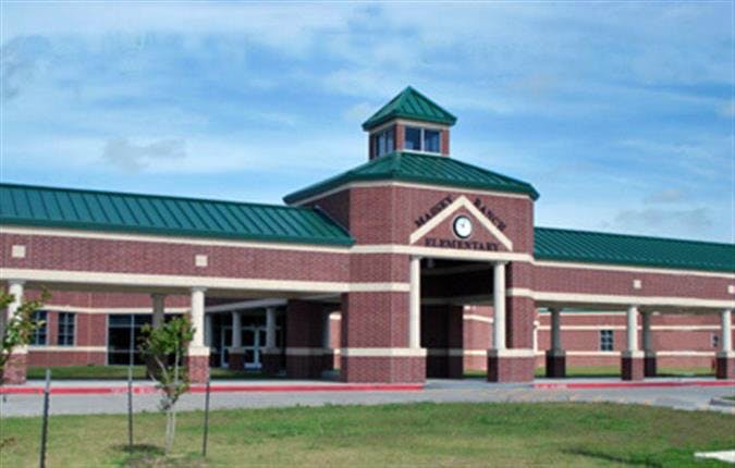 Brick building with a green roof and a sign that reads "Elementary"