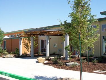 Building exterior with covered entrance and trees