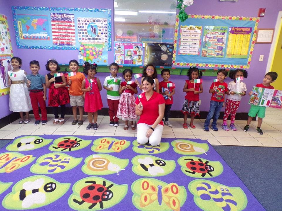 Adult and children standing in a classroom