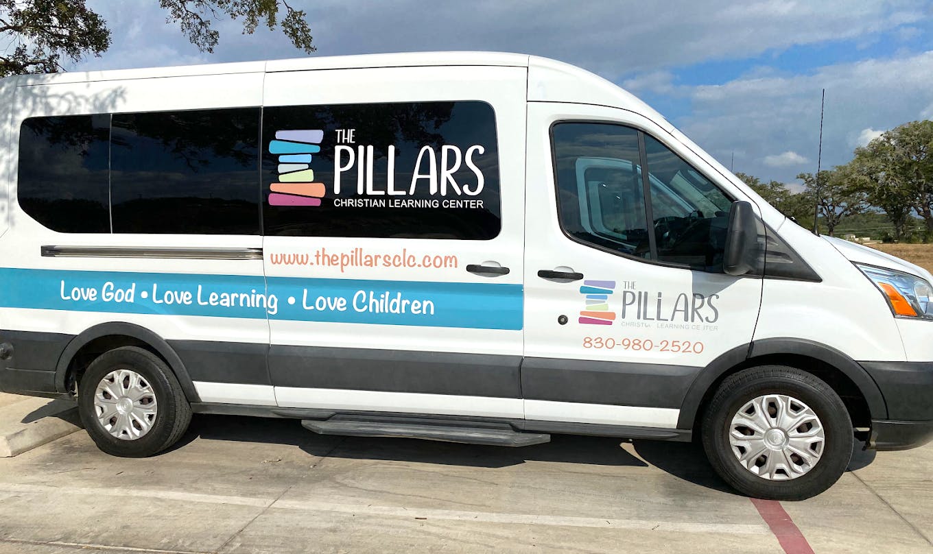 White passenger van with The Pillars Christian Learning Center branding