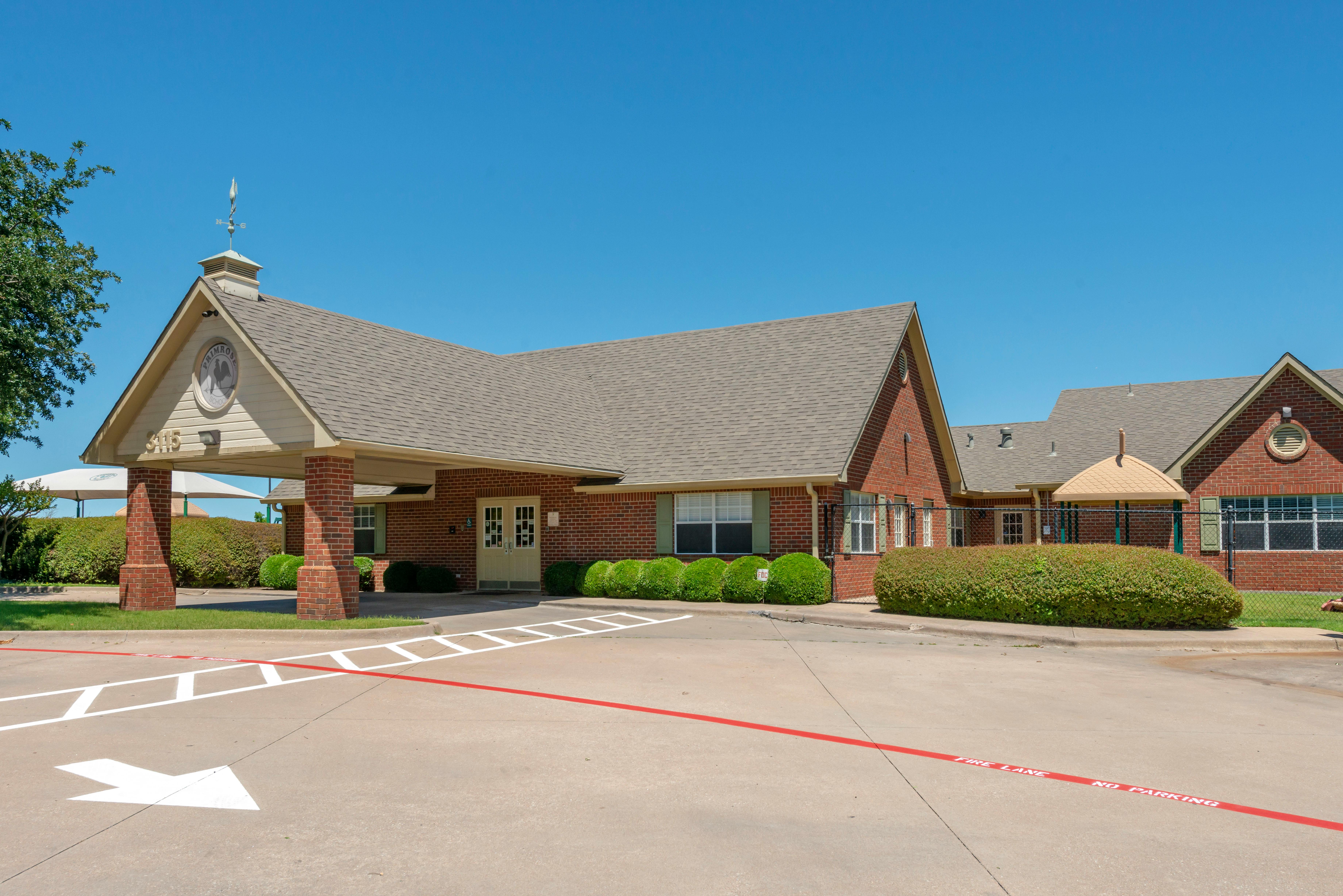 Brick building with a drive-through entrance, labeled "Primrose School"