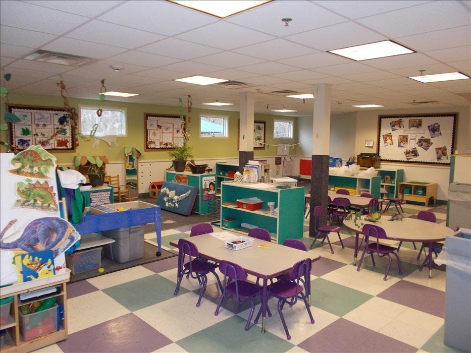 Classroom with small tables and chairs, cubbies, and decorations