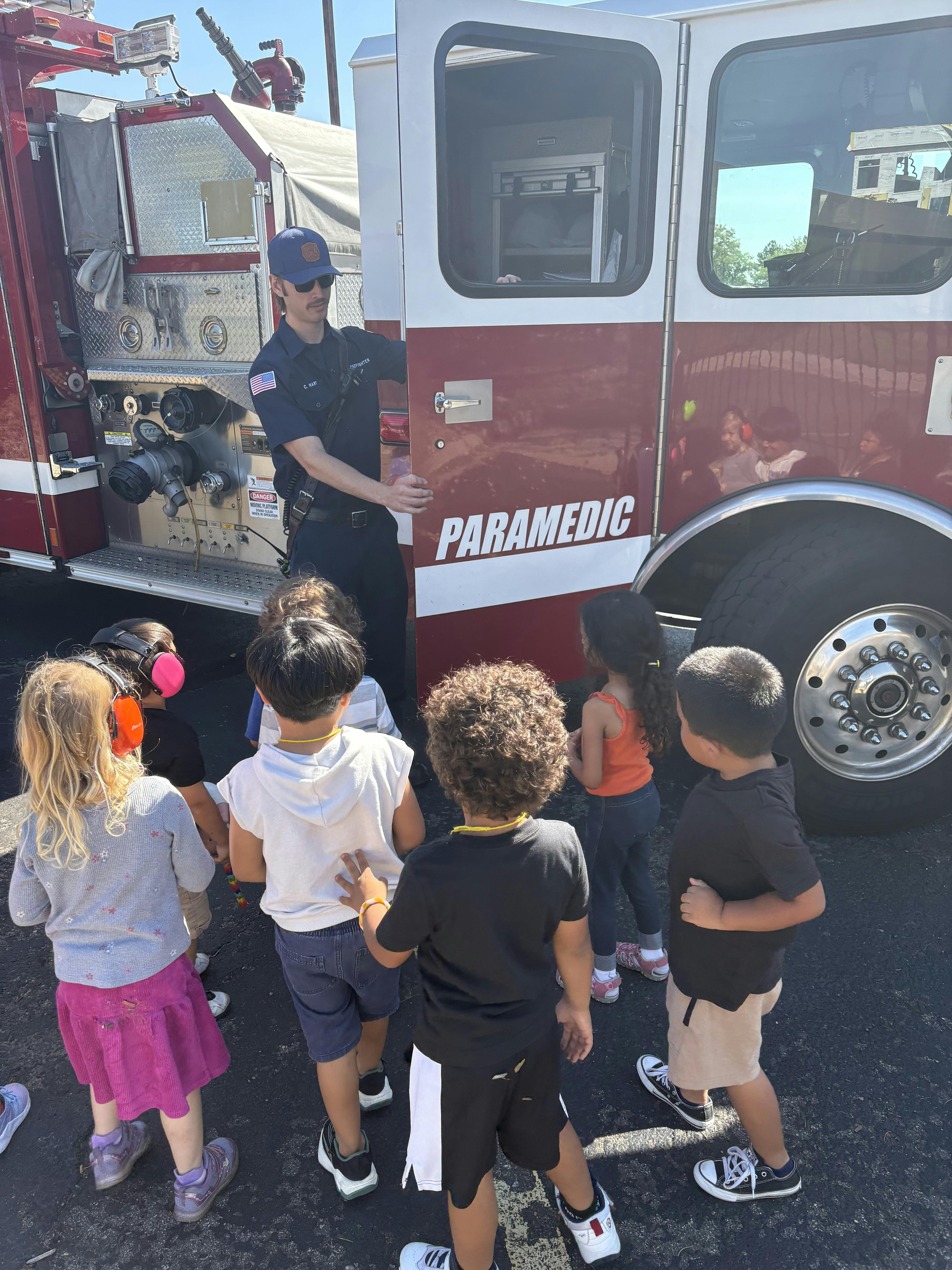 Paramedic showing children a fire truck
