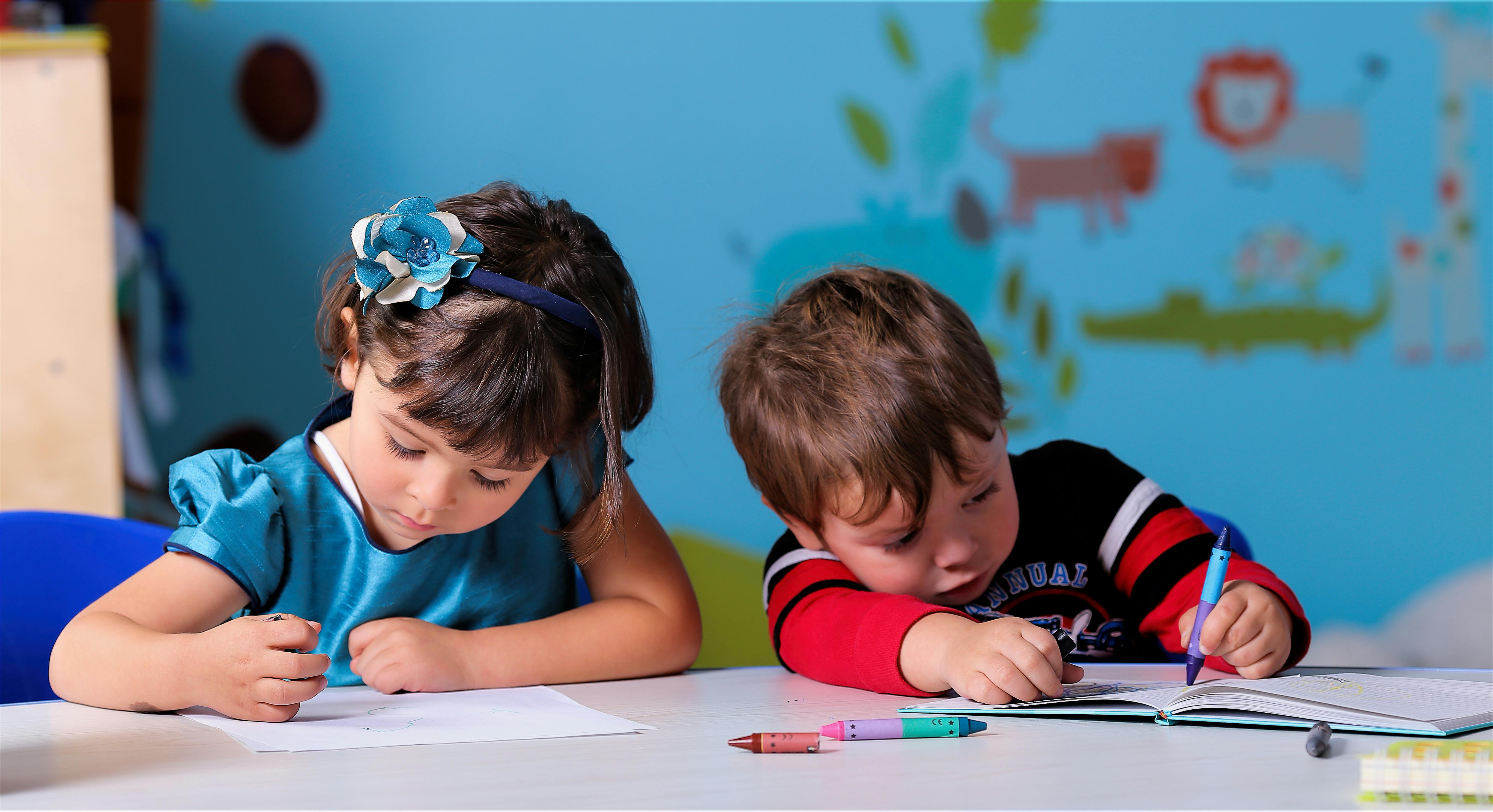 Two children drawing at a table