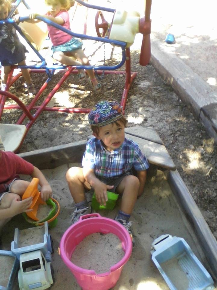 Children playing in a sandbox with toys