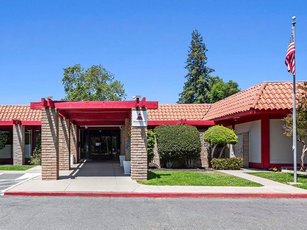 KinderCare building entrance with a red roof and American flag