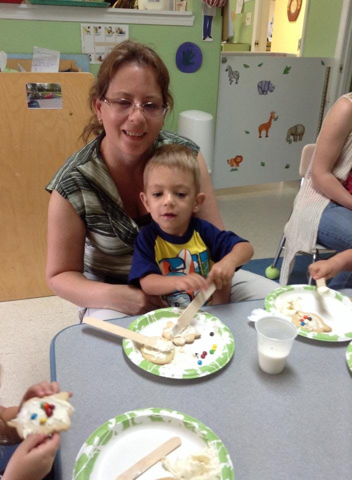 Person and child decorating cookies at a table