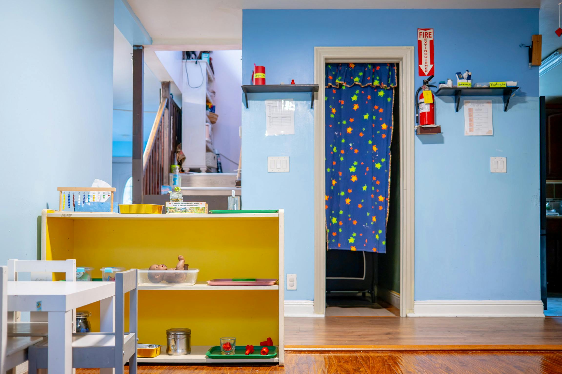 Children's play area with yellow shelves and a small white table and chairs