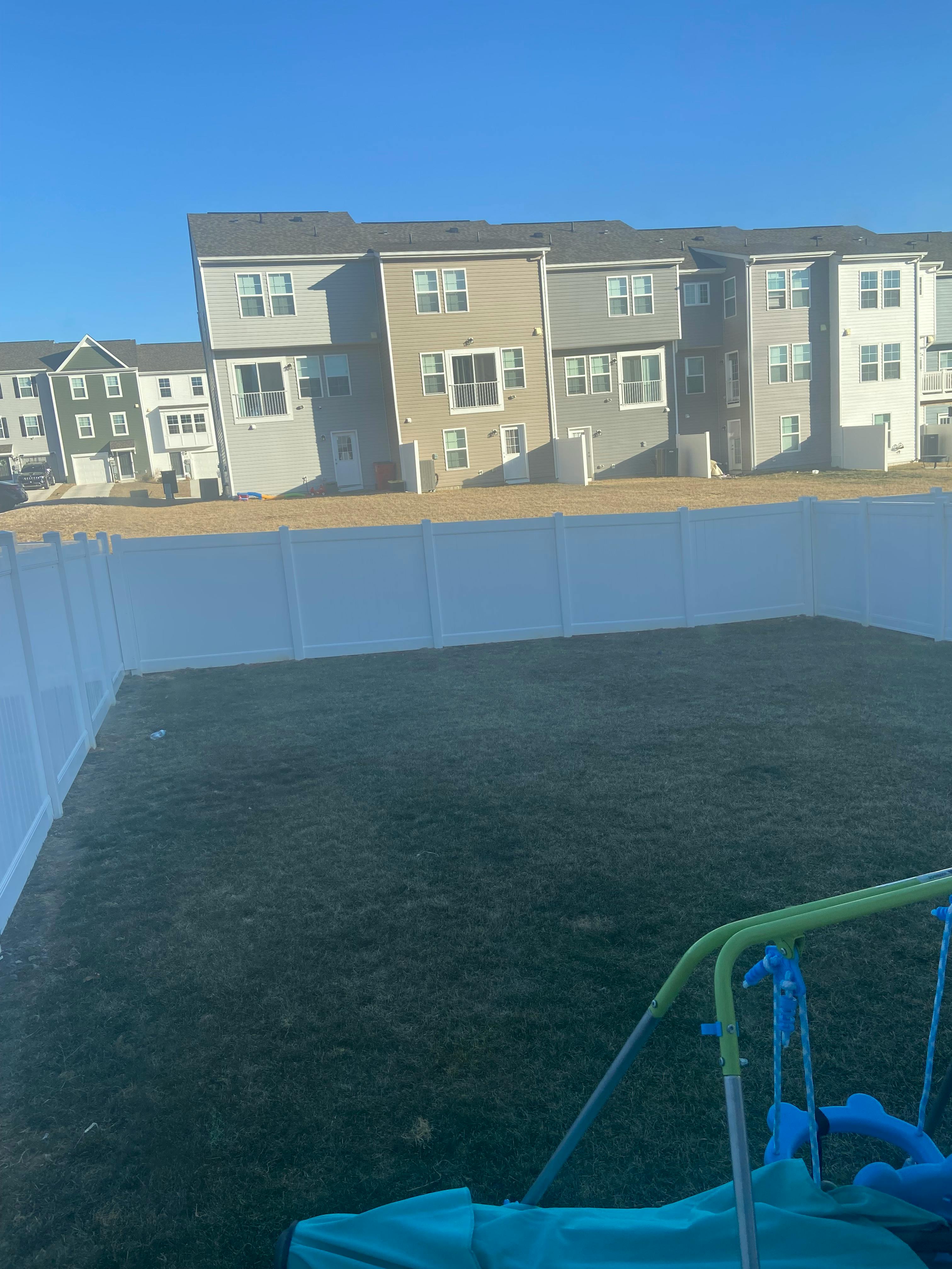 backyards of residential buildings with a white fence