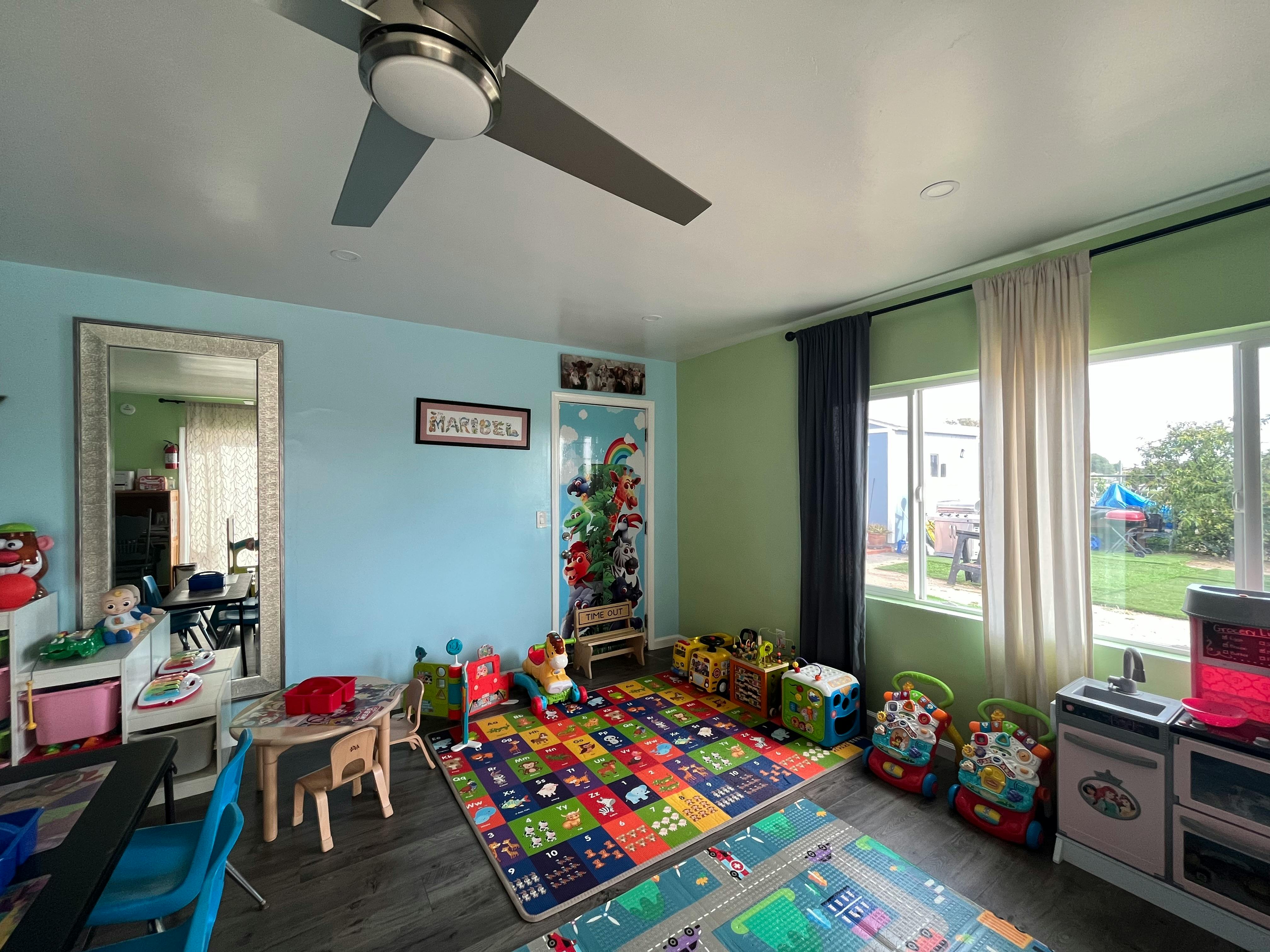 Playroom with colorful rug, small table and chairs, and toys