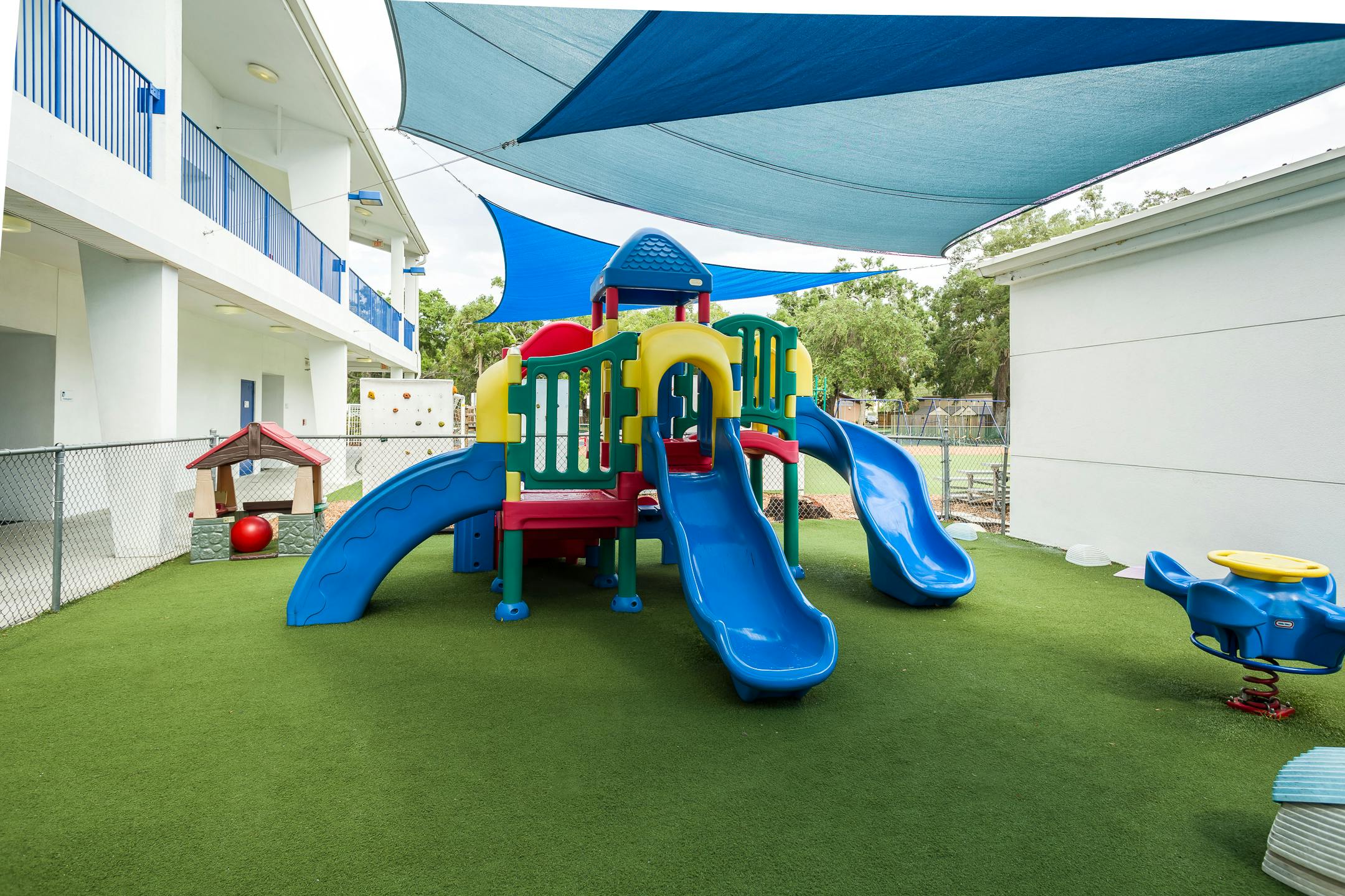Playground with slides and climbing structure on artificial turf