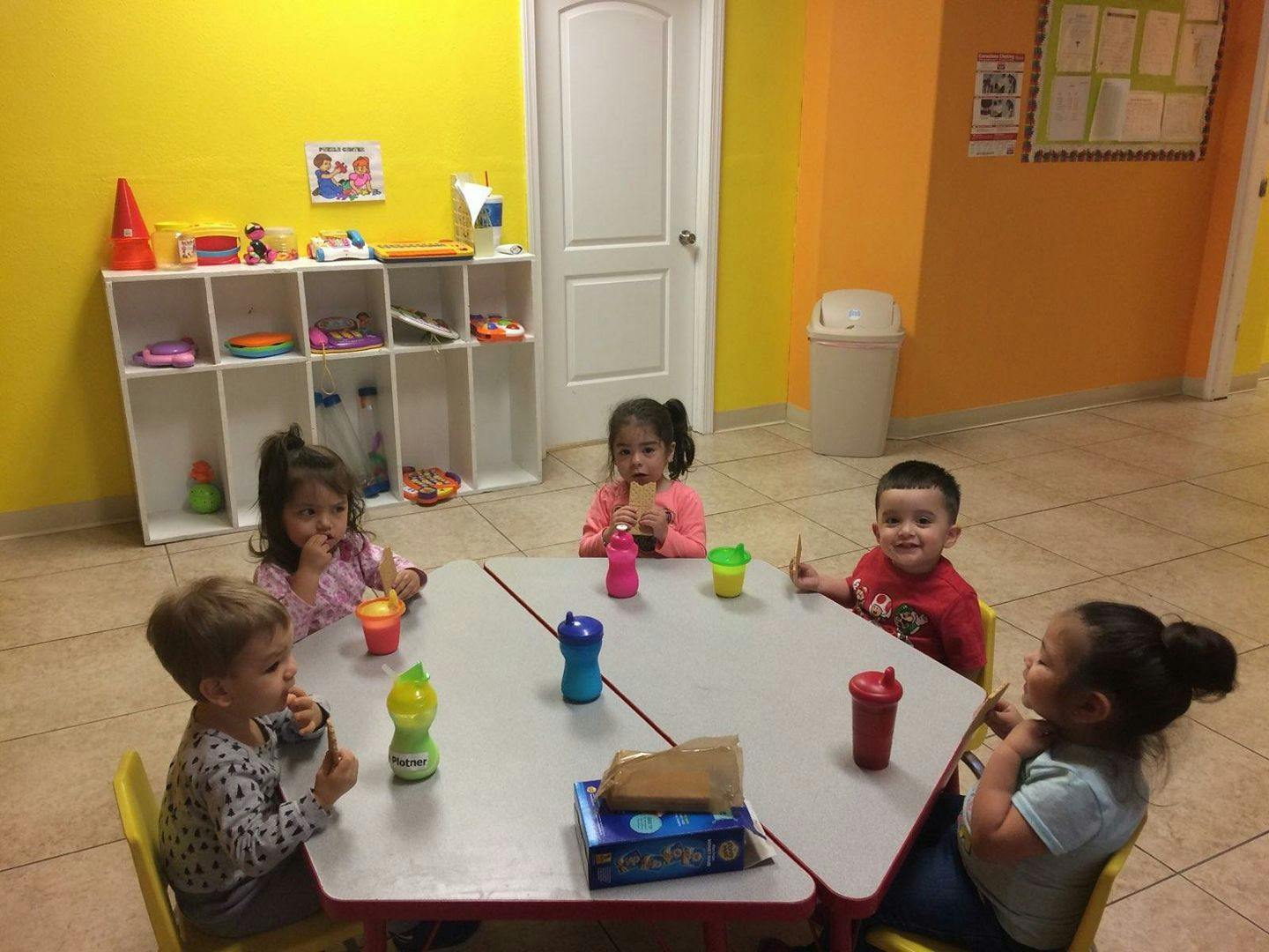 Four children sitting around a table in a classroom