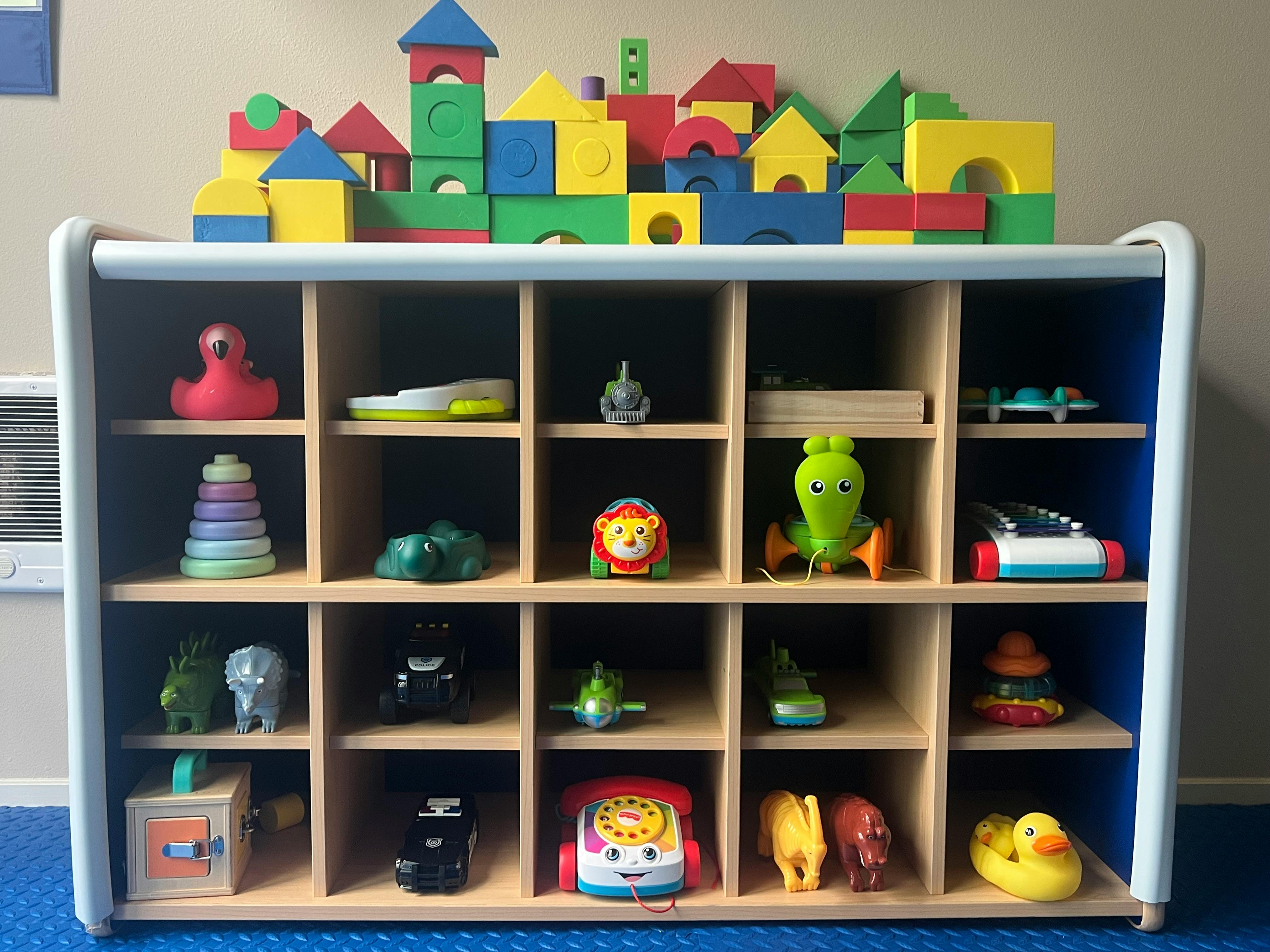 Shelf with various toys and colorful building blocks on top