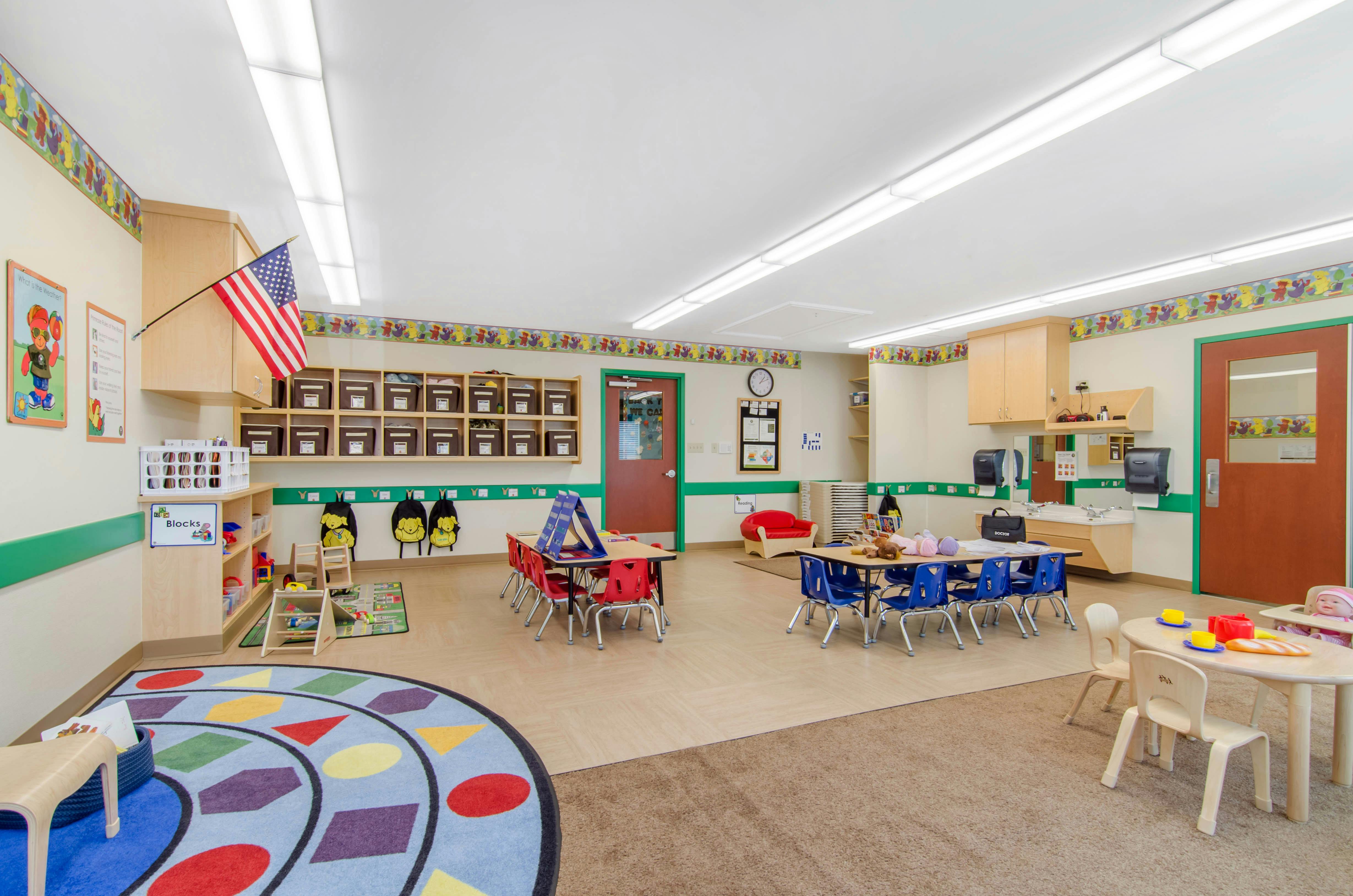 A colorful empty classroom with small tables and chairs