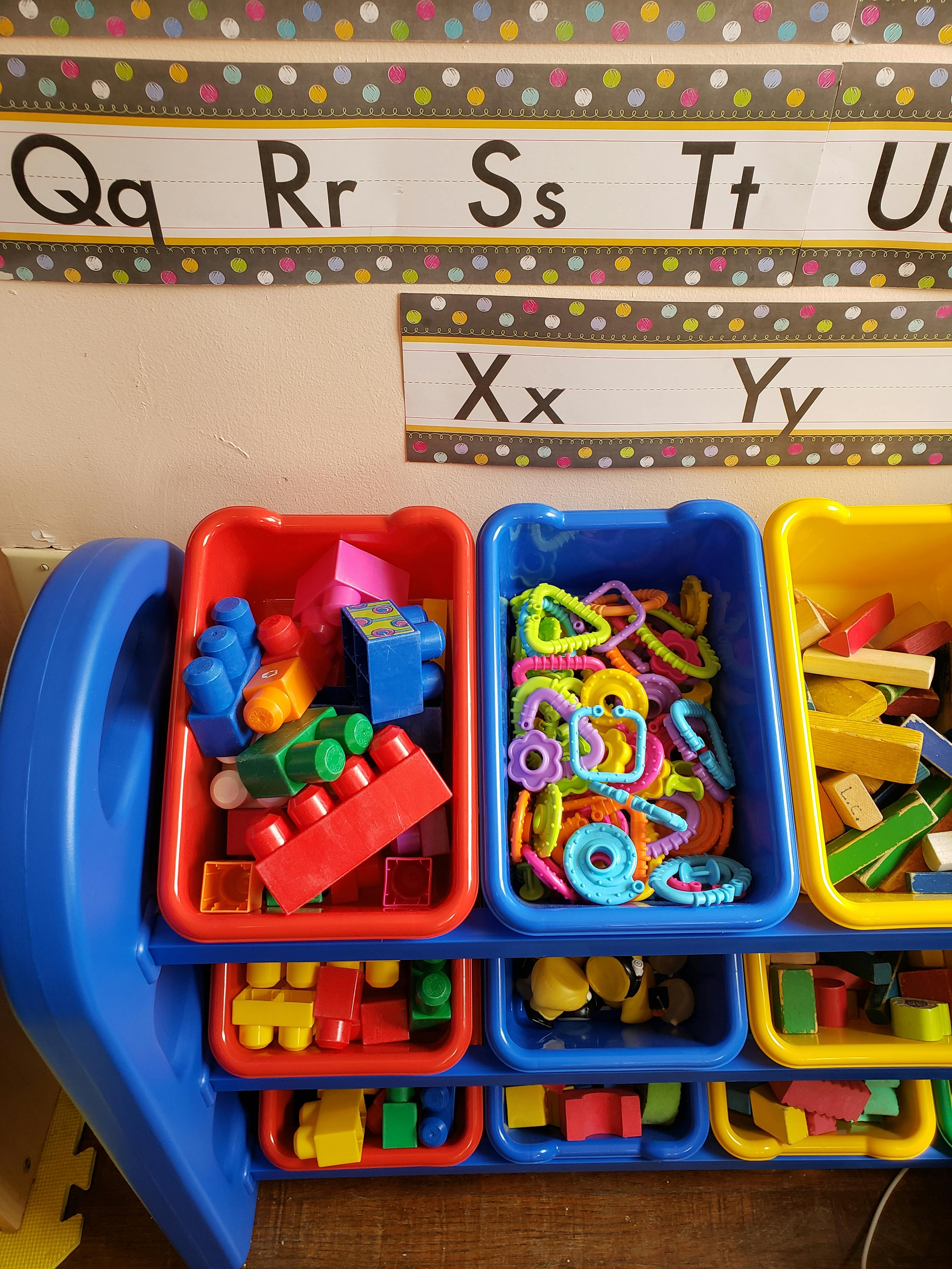 Toy organizer with bins of colorful building blocks and linking toys
