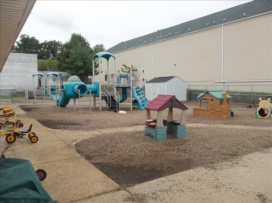 An outdoor playground with slides, swings, and playhouses on wood chips