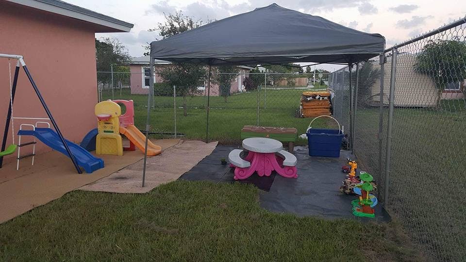 Outdoor play area with swings, slides, and a canopy overhanging canopy