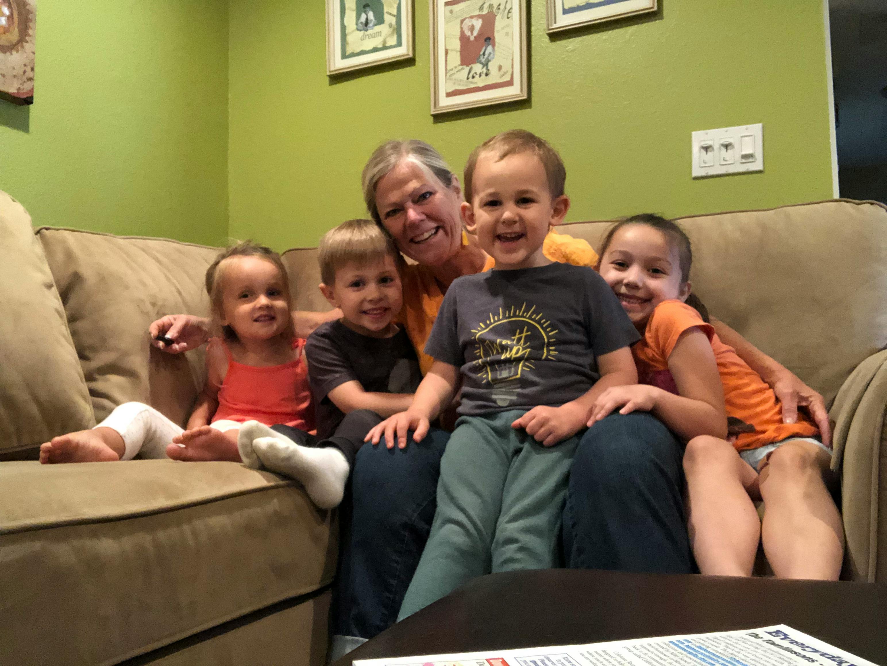 Person sitting on a couch with four children