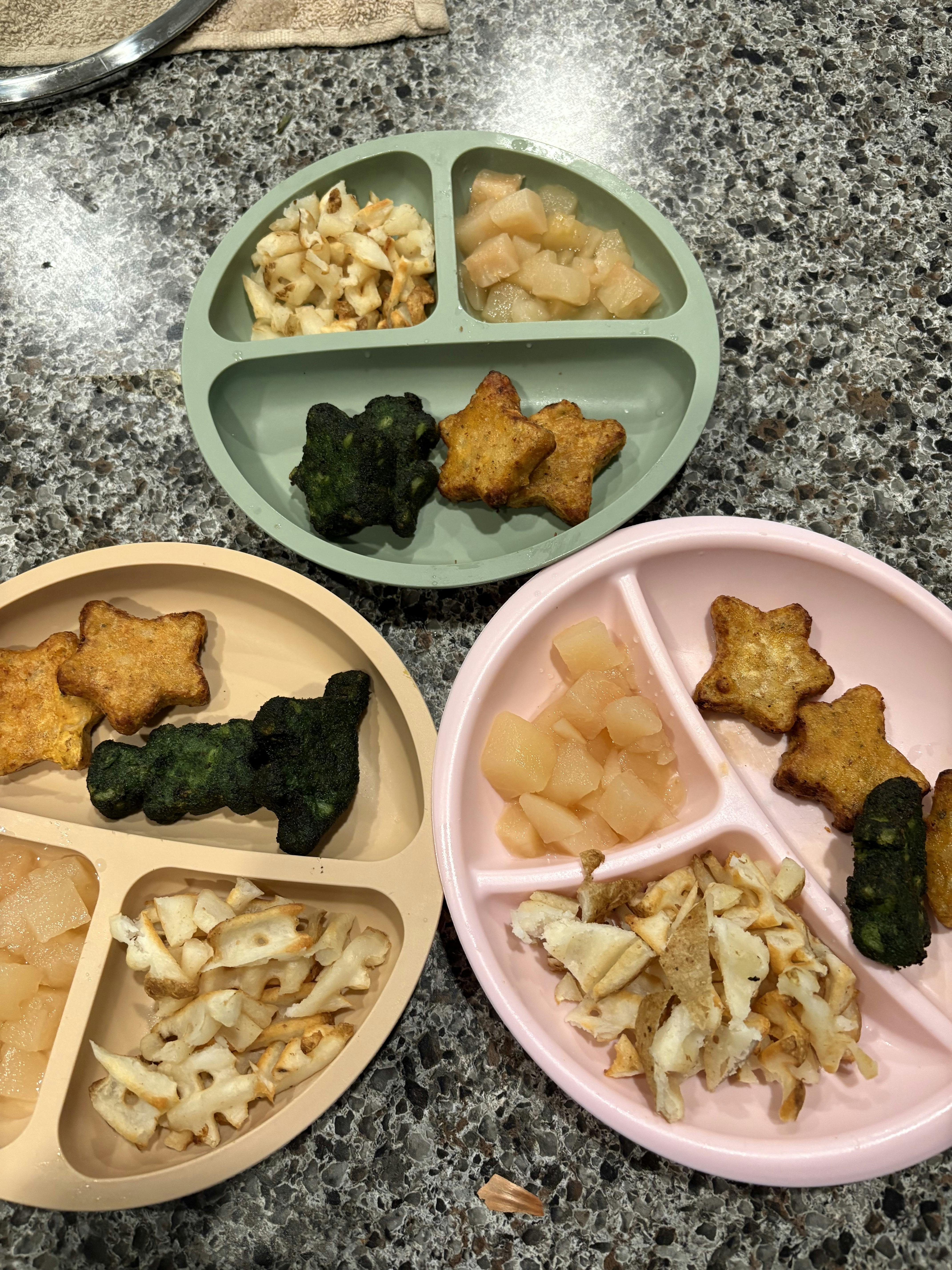 Three partitioned plates with star-shaped foods, broccoli, and diced potatoes