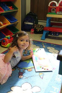 Child lying on a rug and drawing