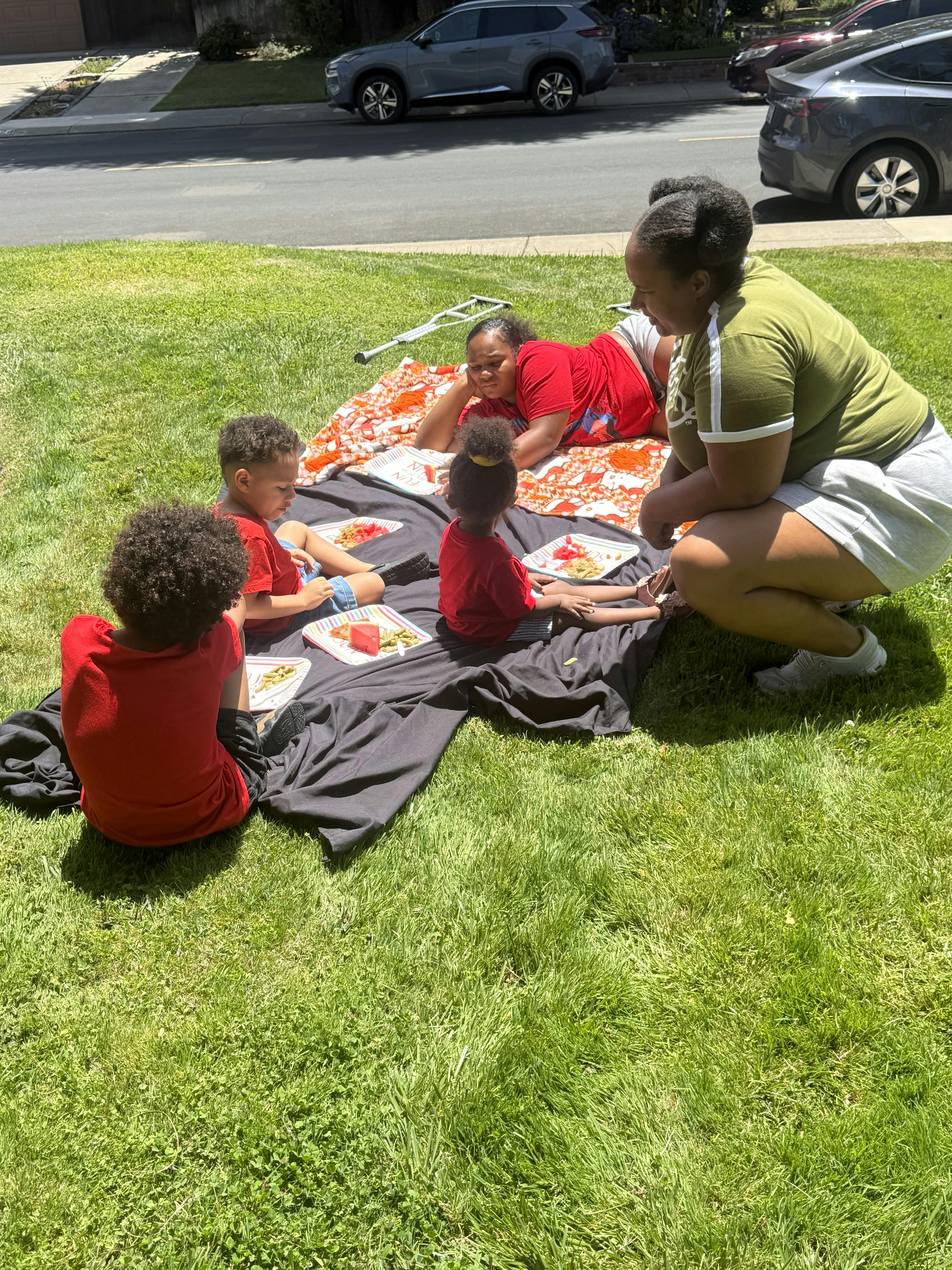 People having a picnic on a blanket on the lawn