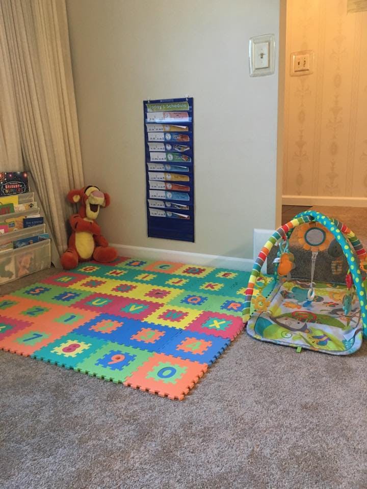 Colorful alphabet play mat and baby activity gym on carpet