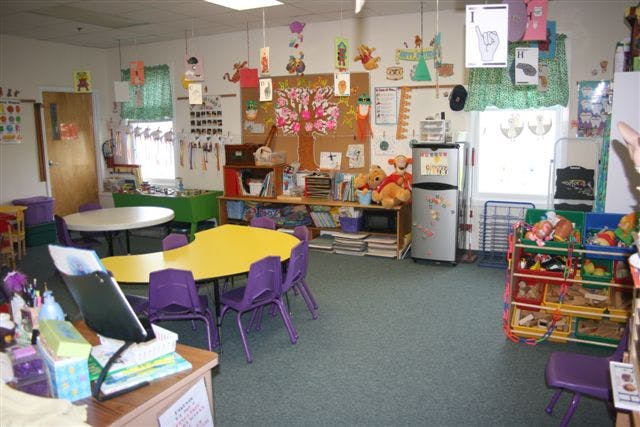 Classroom with yellow and white tables and purple chairs