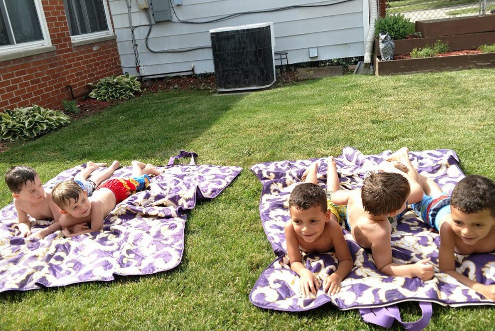 Children lying on blankets on grass