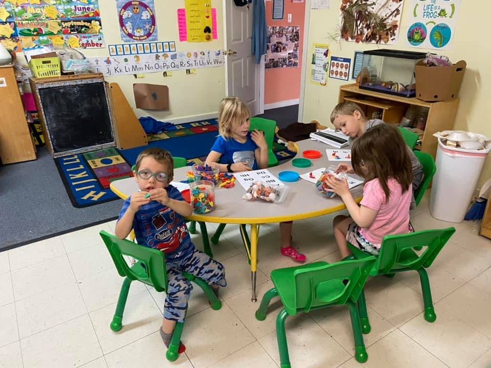 Children sitting at a table in a classroom