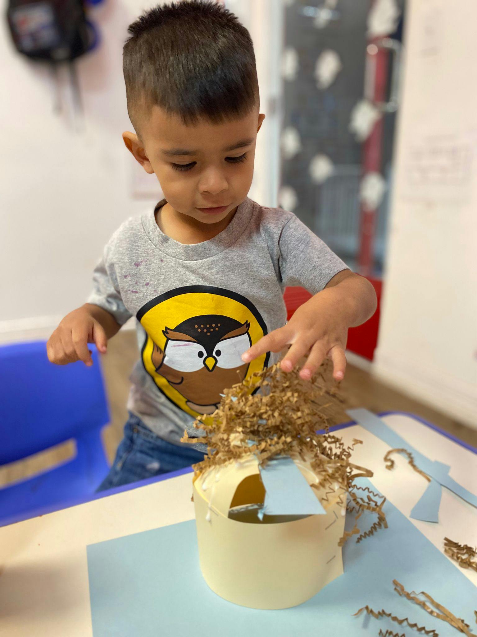 Child making a craft with paper and shredded material