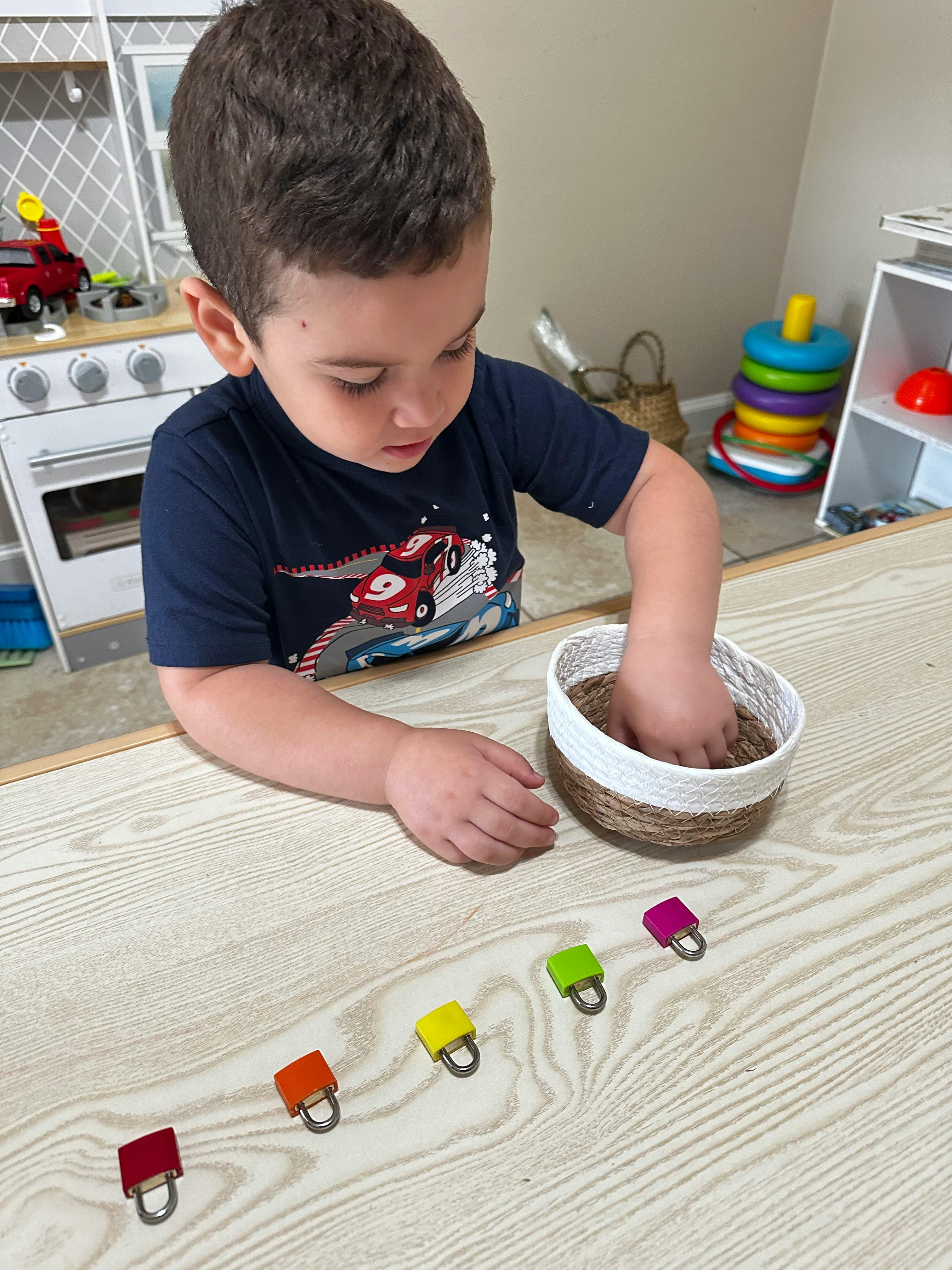 Child playing with colorful locks and a bowl of sand