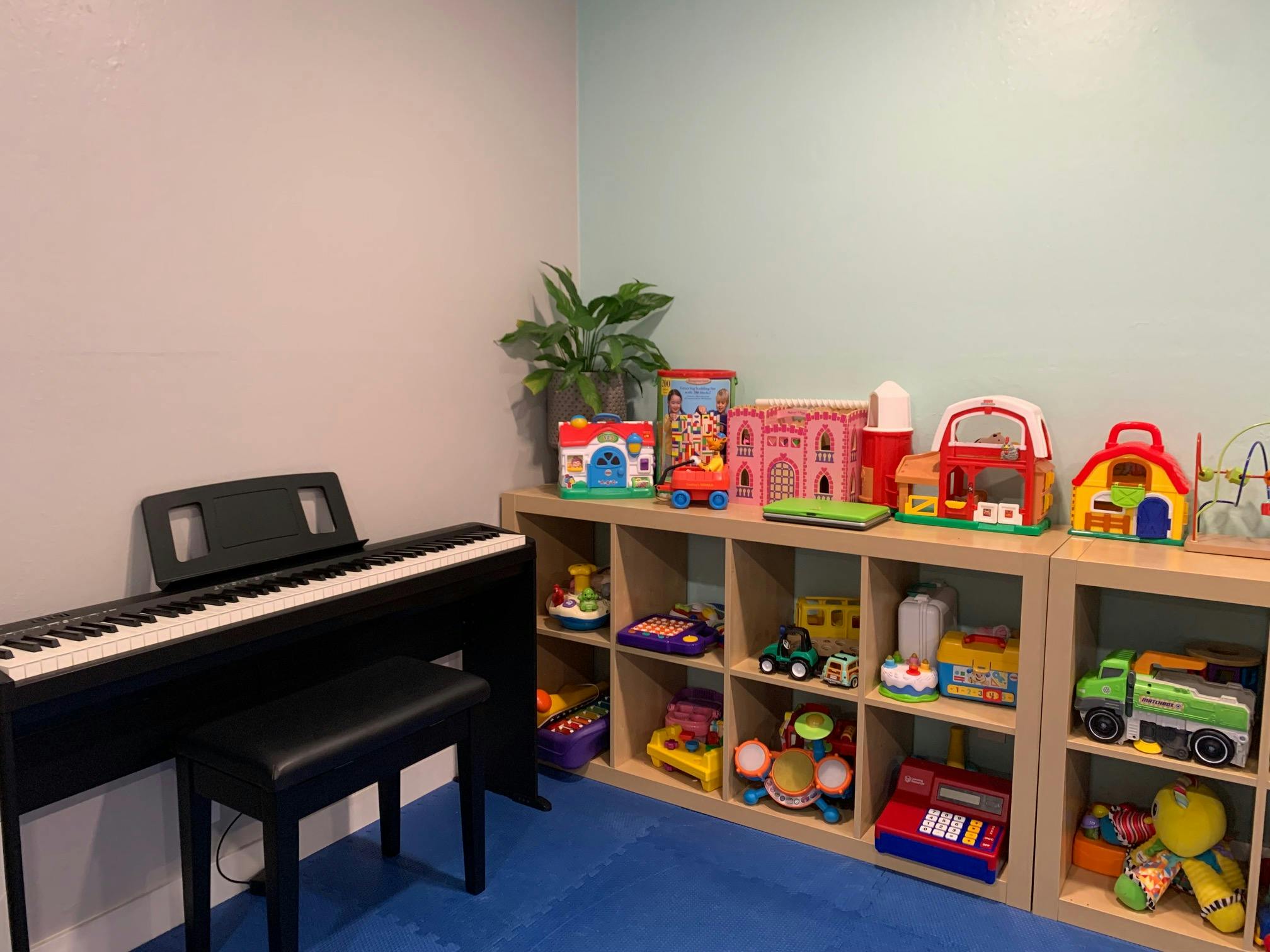 Digital piano next to shelves filled with children's toys
